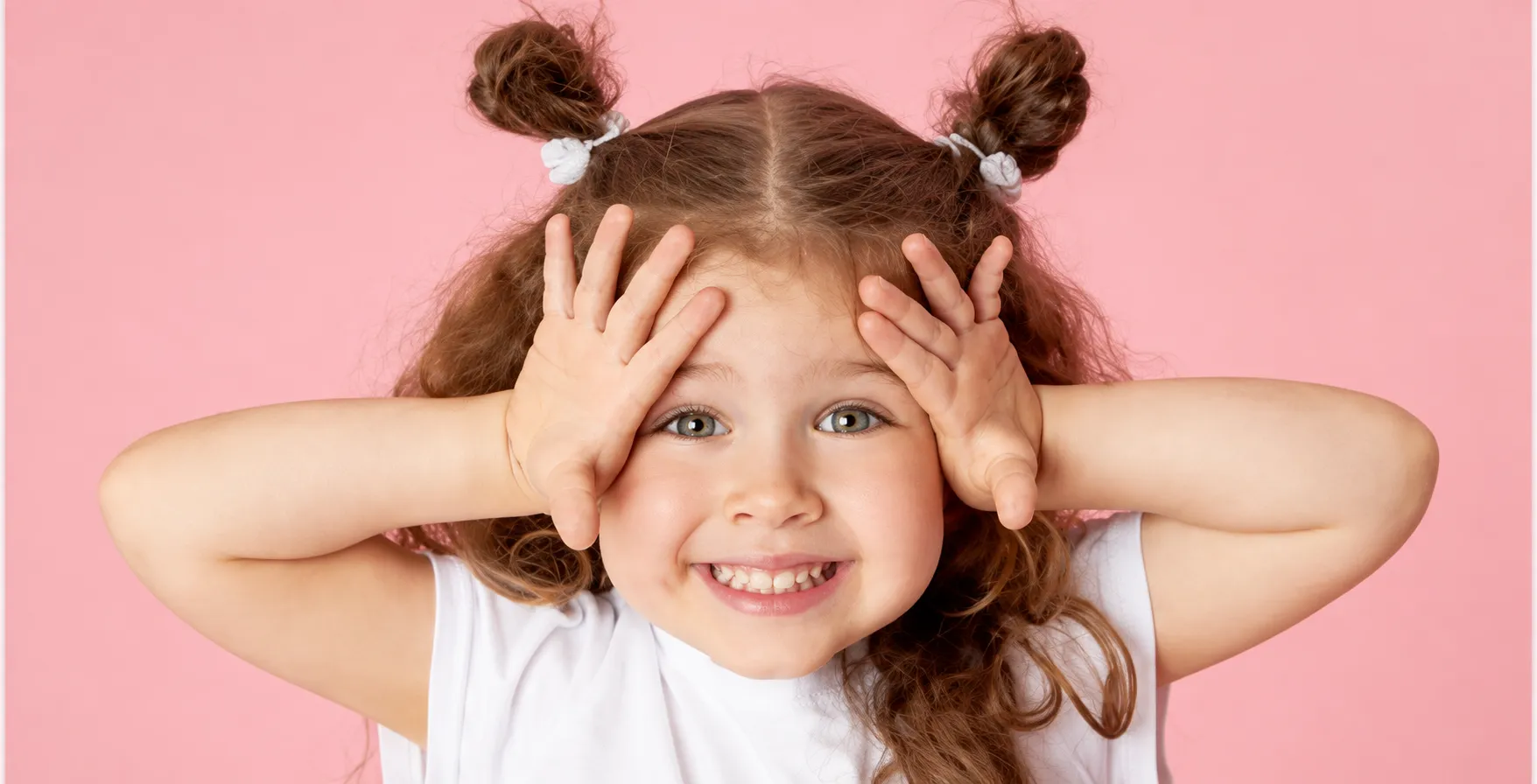 Happy child smiling against a pink backdrop
